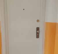 Fehér ajtók a négy szobás lakás folyosóján narancssárga falakkal.