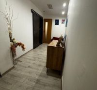 Keskeny belső folyosó fa dekor padlóval, dekorációval és ajtókkal.