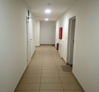 Folyosó fehér falakkal, csempével és vészhelyzeti felszereléssel egy garzonlakásban.