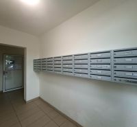 A garzonlakás előszobájában lévő postaládák, csempézett padló, egyszerű dizájn.