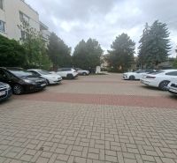 A Dunaszerdahelyi Sport utcában, az épület előtti parkoló autókkal.