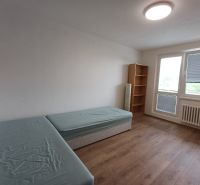 Kétágyas szoba, polccal és fa dekoros padlóval egy háromszobás lakásban.
