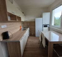 Konyha egy háromszobás lakásban, fa dekoros padlóval és modern berendezéssel.