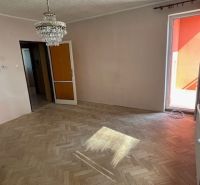 Nappali egy háromszobás lakásban fa dekoros padlóval és csillárral.