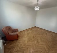 Szoba egy kétszobás lakásban fa dekor padlóval és egy székkel.