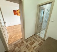 A kétszobás lakás folyosója fa mintázatú padlóval és csempével.