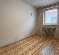 Szoba fa dekor padlóval, radiátorral és tapétával egy családi házban.