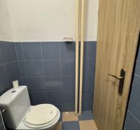 Kék csempés WC a kétszobás lakásban, fa dekoros ajtókkal.