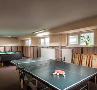 Pingpongasztal és biliárdasztal a szállodák és panziók játéktermében fa dekorációval.
