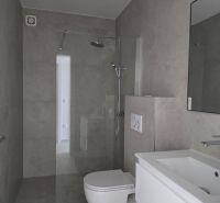 Fürdőszoba zuhanyzóval, mosdóval és WC-vel egy 4 szobás lakásban.