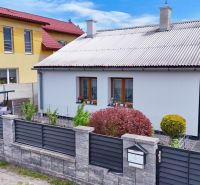 Családi ház Košťany nad Turcom-ban, rendezett kerttel és modern kerítéssel.