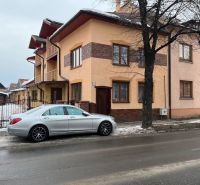 Családi ház Liptószentmiklóson egy autóval a havas utcán.