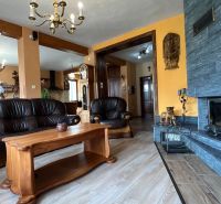 Bőr ülőgarnitúra és kandalló, fa dekoros padló, elegáns villa belső tér.