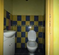 Fürdőszoba mosdóval és WC-vel egy háromszobás lakásban, színes csempék.