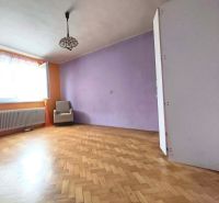Nappali egy háromszobás lakásban, fa dekoros padlóval és lila fallal.
