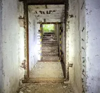 Elhagyatott lépcsőház egy földalatti bunkerben, Különleges ingatlanok Humenné, sérült falakkal.