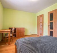 Hálószoba családi házban fa bútorokkal és fa dekoros padlóval.
