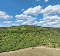 Mezőgazdasági és erdőterületek Tornalján gyönyörű zöld dombokkal és kék éggel.