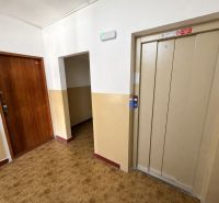 3 szobás lakás előszobája lifttel és fa dekorációjú padlóval.