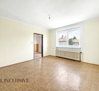 Tágas szoba fa mintázatú padlóval és nagy ablakkal egy családi házban.