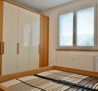 Hálószoba ággyal matrac nélkül, beépített szekrénnyel és ablakkal, 3 szobás lakás.