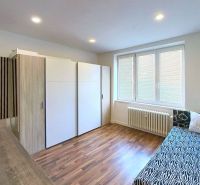 Szoba ággyal, szekrénnyel és fa dekorációjú padlóval a Nyaraló apartmanban.