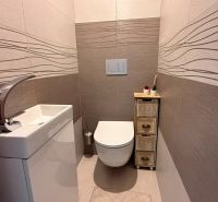 Hangulatos WC egyszerű mosdóval és dekoratív csempékkel egy 4 szobás lakásban.