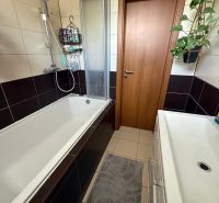 Fürdőszoba egy háromszobás lakásban káddal, mosdóval és csempével, amely kényelmet biztosít.