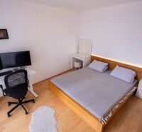 Hálószoba ággyal, íróasztallal és fa dekoros padlóval egy 4 szobás lakásban.