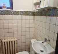 Fürdőszoba családi házban WC-vel, mosdóval és ablakkal, csempézett.