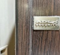 ADLO biztonsági ajtó részletei egy háromszobás lakásban, fa mintázatú padlóval.