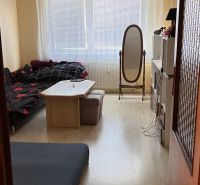 Nappali egy kétszobás lakásban, fa mintázatú padlóval és bútorokkal.