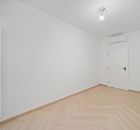 Világos szoba fehér falakkal és fa dekorációjú padlóval.