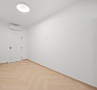 Fehér szoba beépített légkondicionálóval és fa dekorációjú padlóval egy 4 szobás lakásban.
