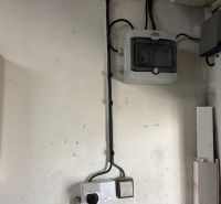 Elektromos szerelés a garázsban szekrénnyel és kábelekkel a falon.