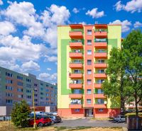 Színes lakóházak a Füleki Sládkovič utcában parkolóval és zöldterülettel.