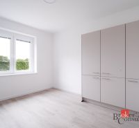 Szoba egy háromszobás lakásban, fa dekoros padlóval és gardróbszekrénnyel.