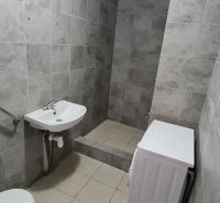 Fürdőszoba csempével, mosdó, WC és mosógép egy kétszobás lakásban.