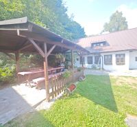 Házikó Špania Dolinában pavilonnal, faasztallal és virágdíszítéssel a kertben.