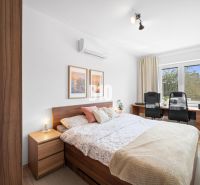 Hálószoba egy kétszobás lakásban fa dekor padlóval és íróasztallal.