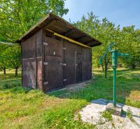 Fából készült pavilon és kézi szivattyú a kertben a Lazy pod Makytou, Dubková melletti háznál.