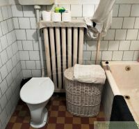 Fürdőszoba családi házban káddal, WC-vel, radiátorral és tároló kosárral.