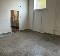 Iroda belső tér fehér falakkal és betonhatású padlóval.