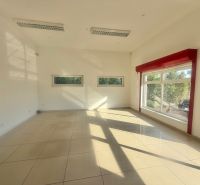 Üzlethelyiség belső tere nagy ablakokkal és fényes csempékkel.