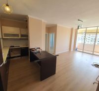 Konyha és nappali a nyaraló apartmanban, fa dekorációjú padló, erkély.