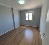 Szoba egy üdülő apartmanban fa dekor padlóval és ablakkal.