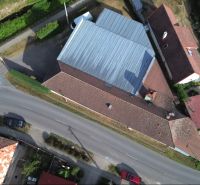 Légi felvétel a zöldterületekkel és közúti infrastruktúrával körülvett budčai gyártóhelyiségekről.