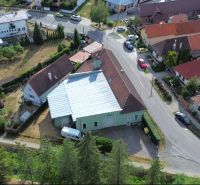 Légi felvétel a Budča községben található gyártóhelyiségekről, amelyeket zöldterület és házak vesznek körül.