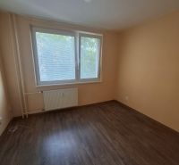 Szoba egy háromszobás lakásban, fa dekoros padlóval és nagy ablakkal.