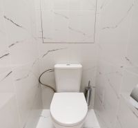 Háromszobás lakás fürdőszobája márvány burkolattal és WC-vel.